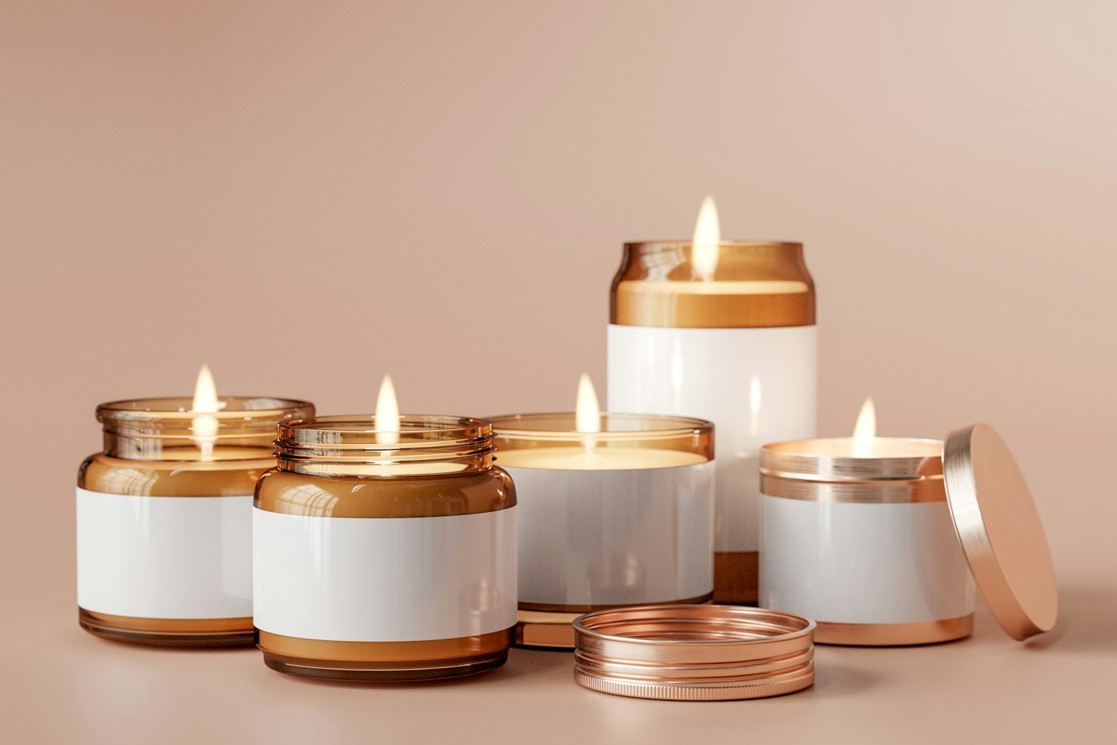 Lit candles in amber glass jars and tins with plain white labels on a beige background