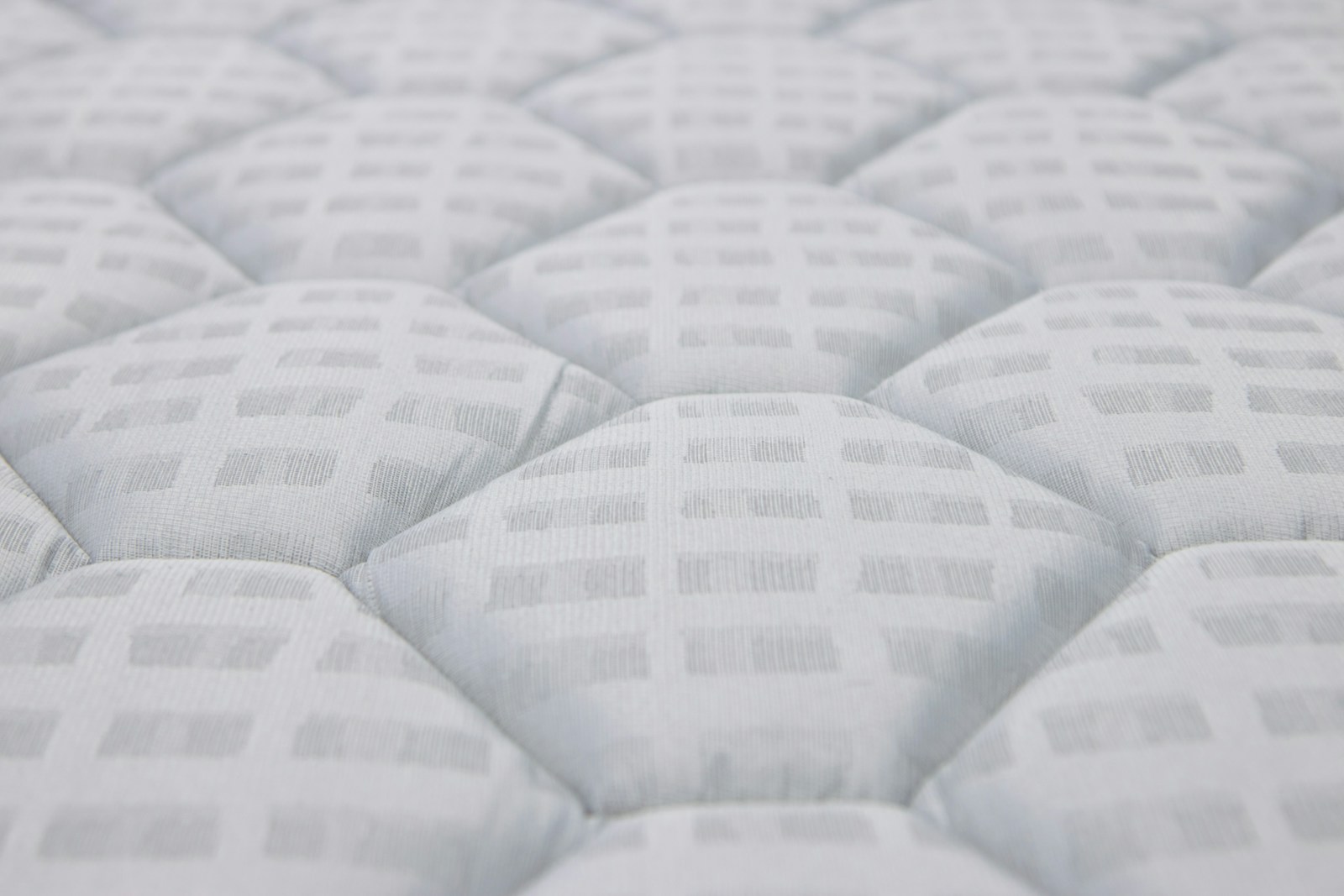 Close-up of a white quilted mattress surface