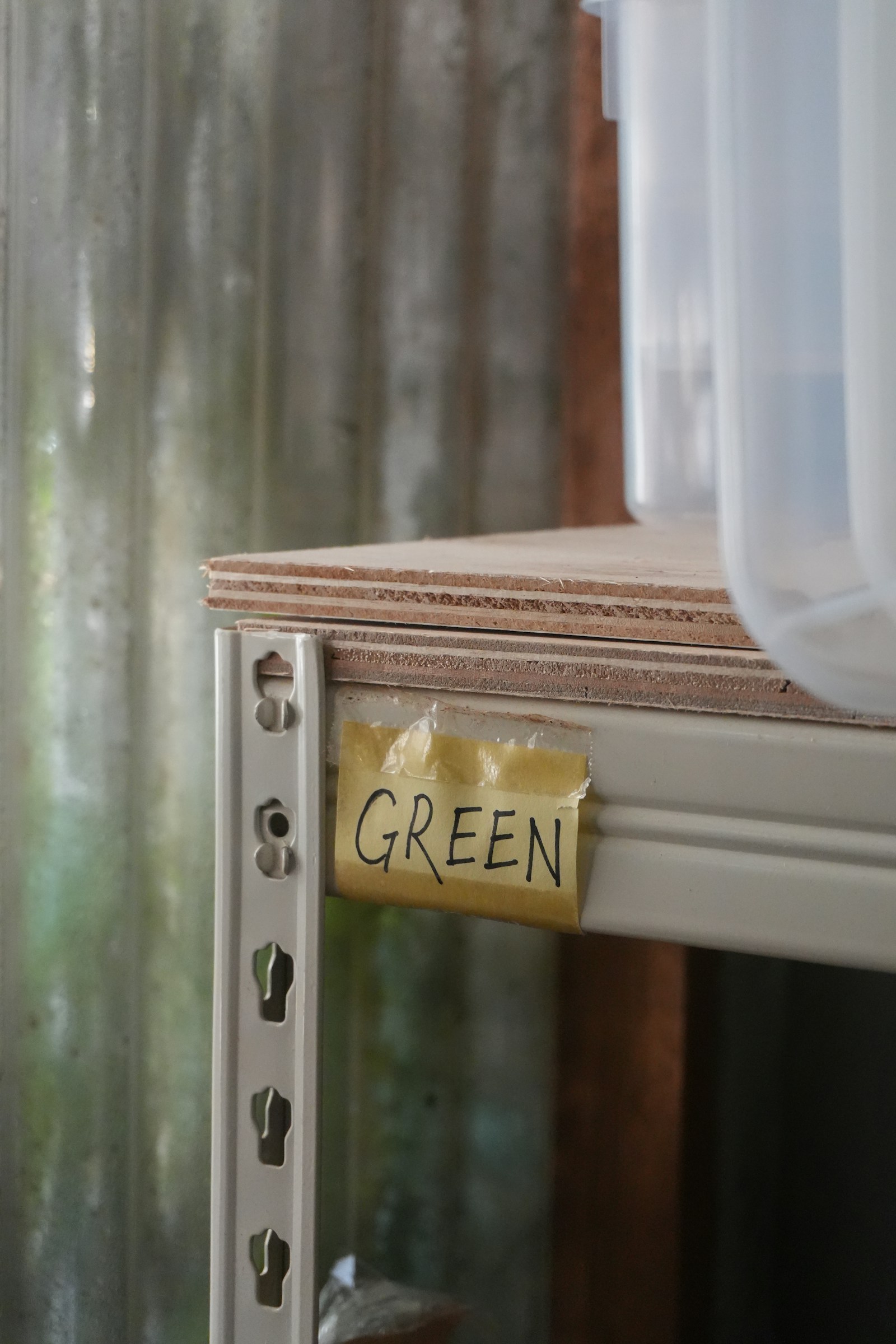 Metal shelving with storage boxes and a handwritten label