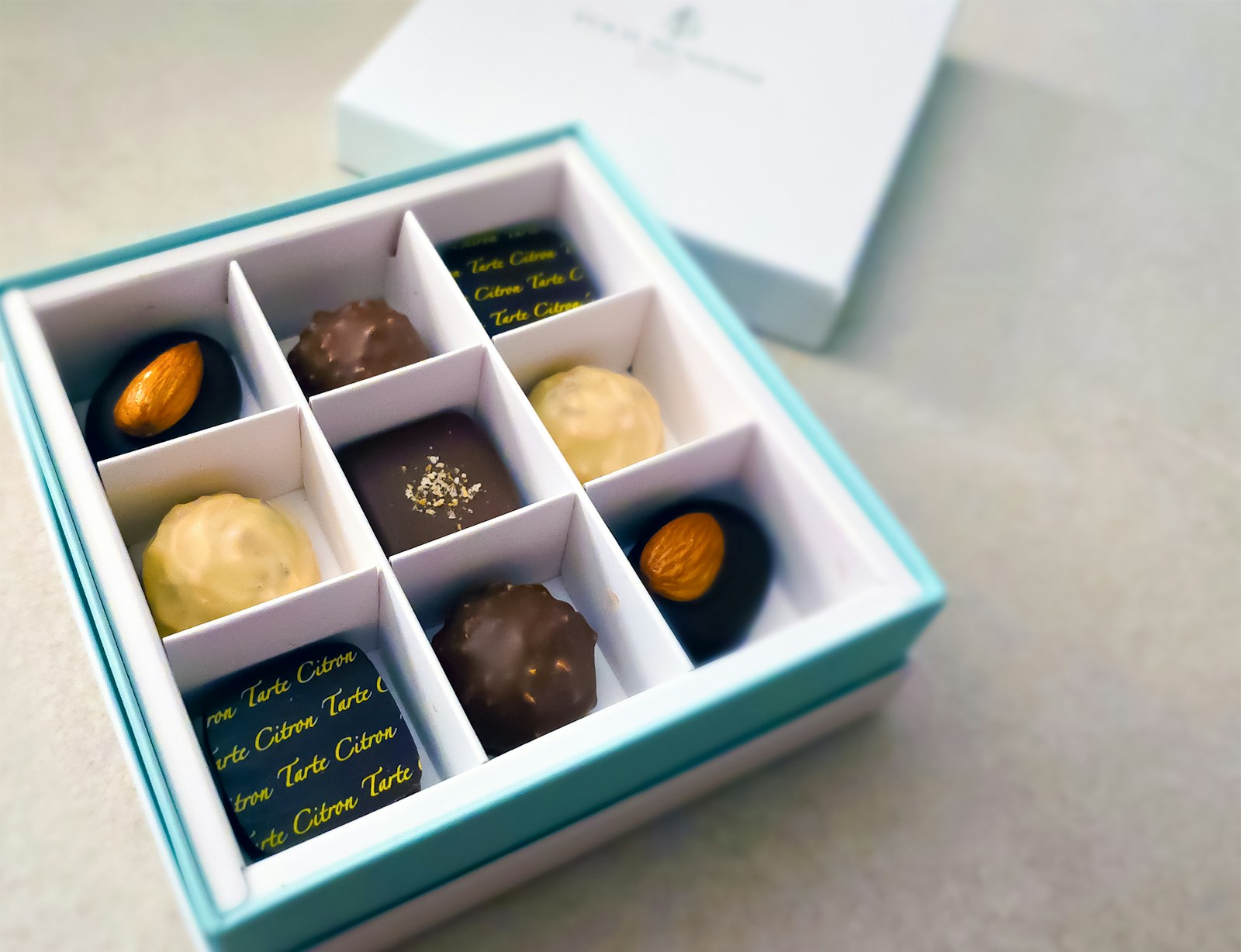 Open gift box of assorted chocolates with almonds and truffles