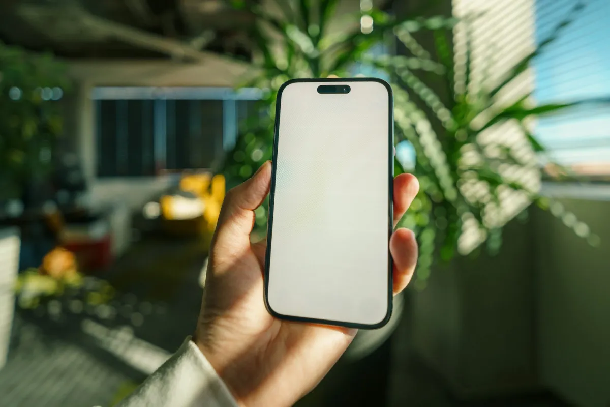 Hand holding a smartphone with a blank screen
