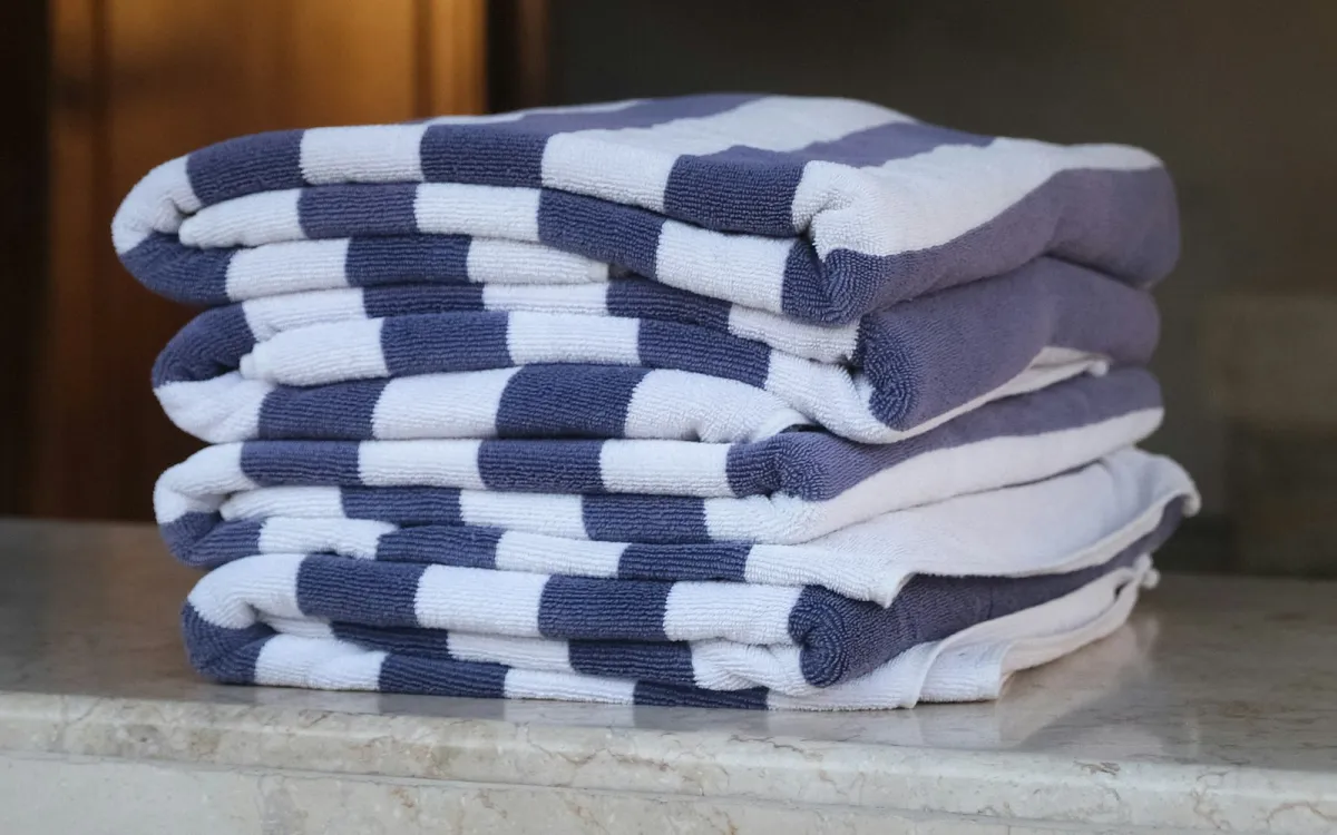 A stack of folded blue and white striped towels on a marble counter