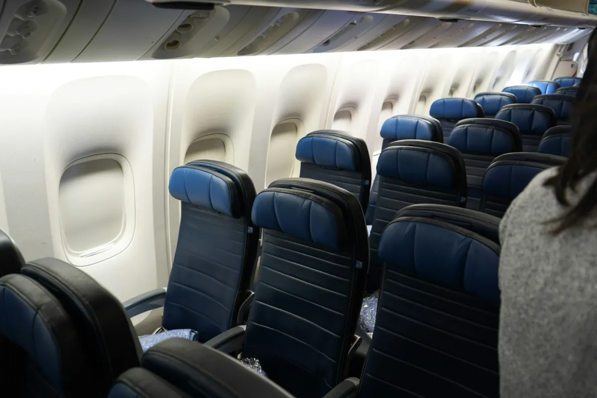Rows of empty blue seats inside an aircraft cabin Rows of empty blue seats inside an aircraft cabin