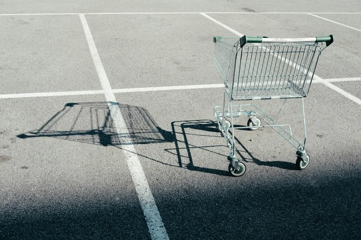 An empty shopping trolley standing in a supermarket car park