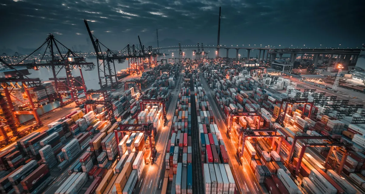 A busy container port at dusk, with rows of stacked shipping containers and cranes A busy container port at dusk, with rows of stacked shipping containers and cranes