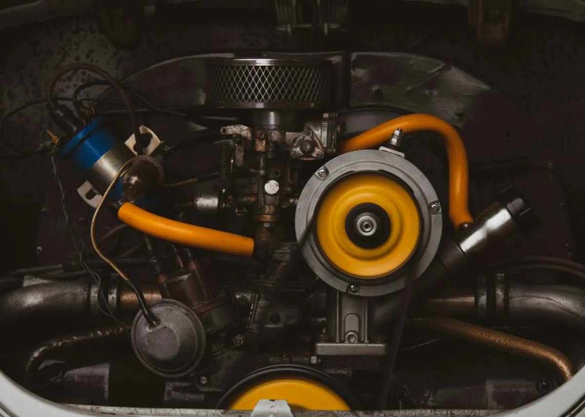 Close-up of a classic car engine with yellow hoses and an air filter