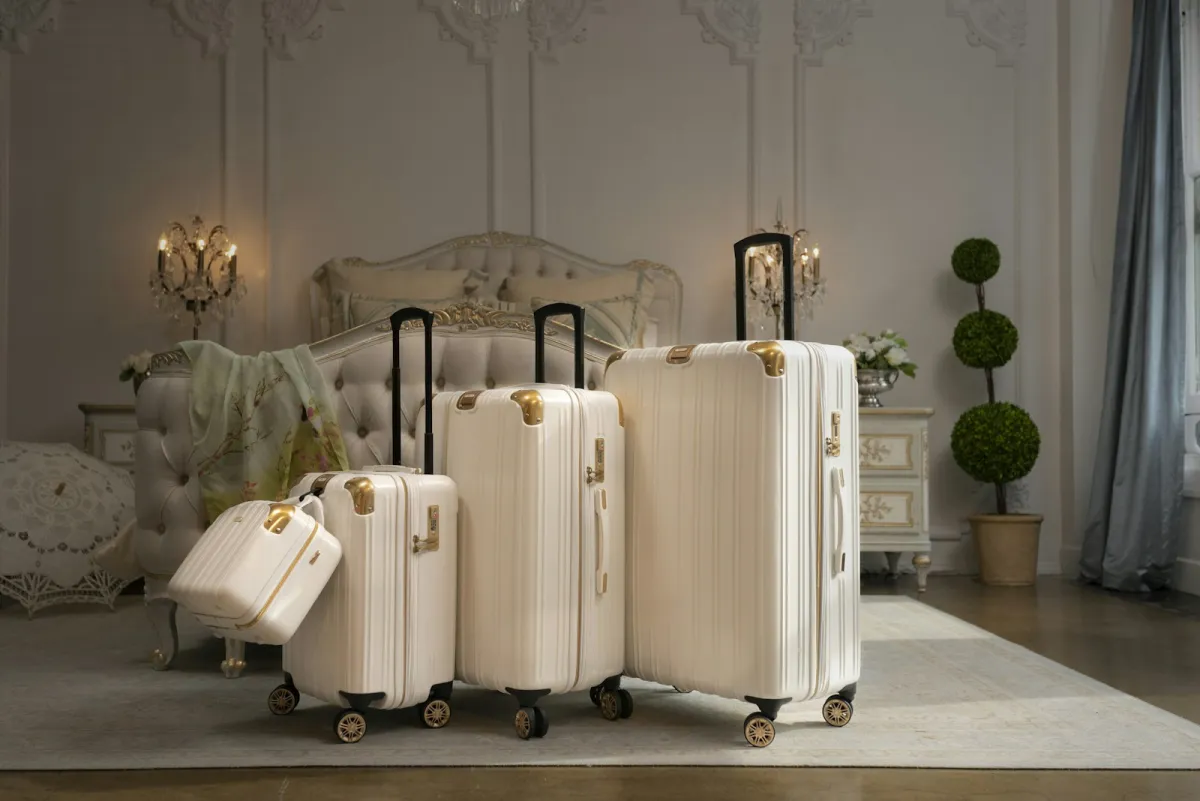 Four white suitcases standing on a rug in a hotel bedroom Four white suitcases standing on a rug in a hotel bedroom