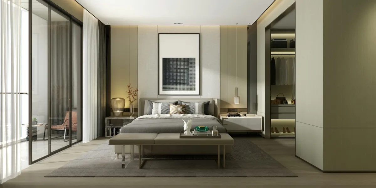 A modern bedroom with a grey upholstered bed, bench at its foot and a framed print above the headboard