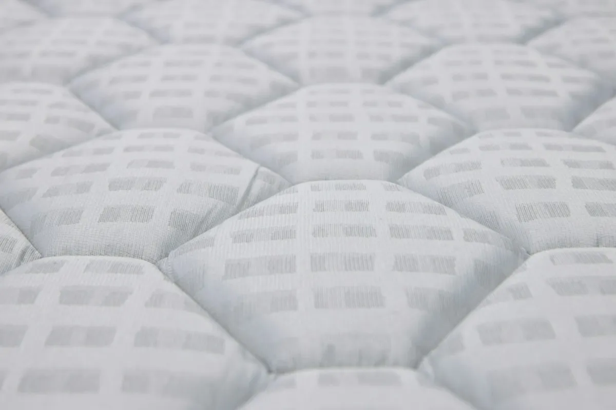 Close-up of a white quilted mattress surface Close-up of a white quilted mattress surface