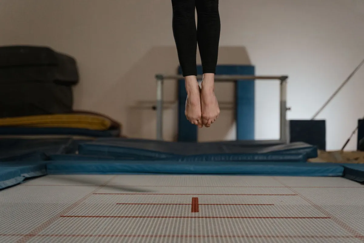 Bare feet mid-bounce above an indoor trampoline