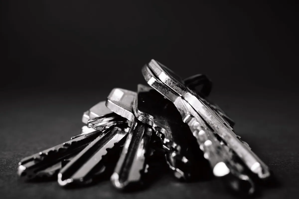 A close-up of a bunch of metal keys on a dark background A close-up of a bunch of metal keys on a dark background