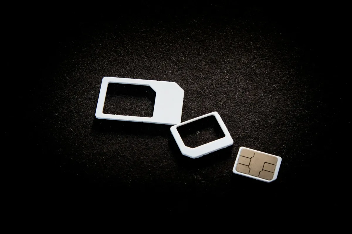 A SIM card and two SIM adaptors on a dark background