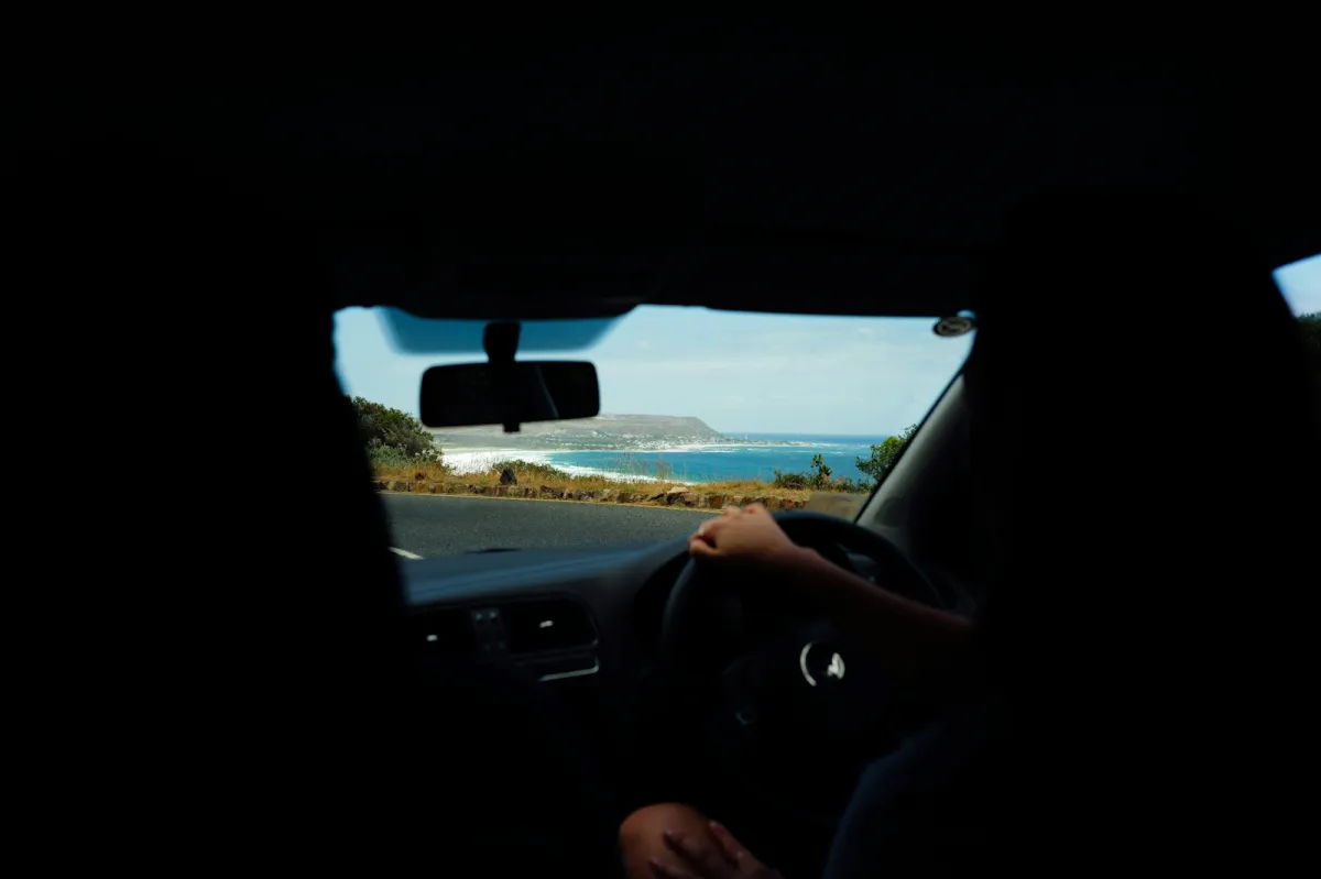 View from a car driving along a coastal road with the sea alongside