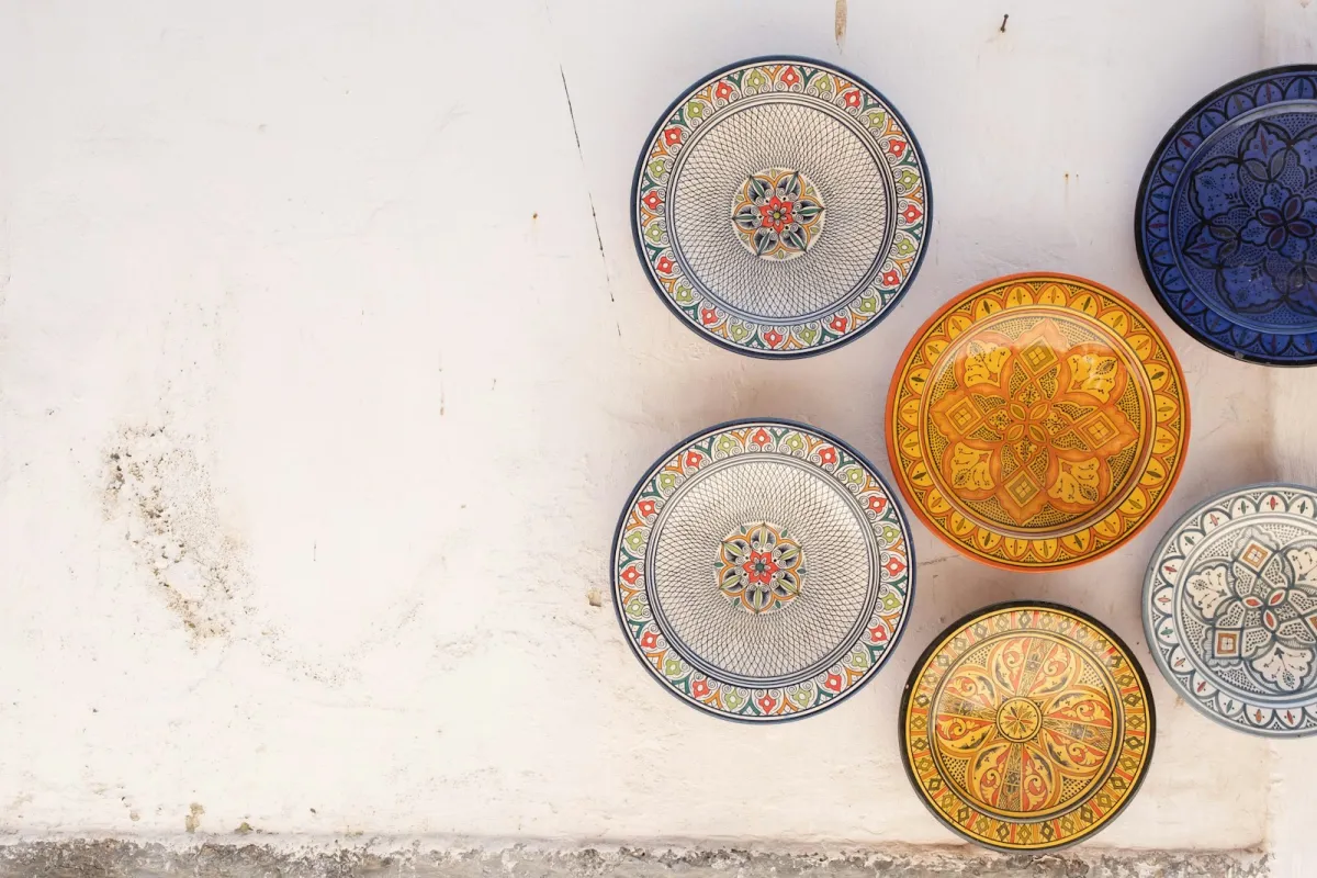 Colourful hand-painted ceramic plates on a whitewashed wall