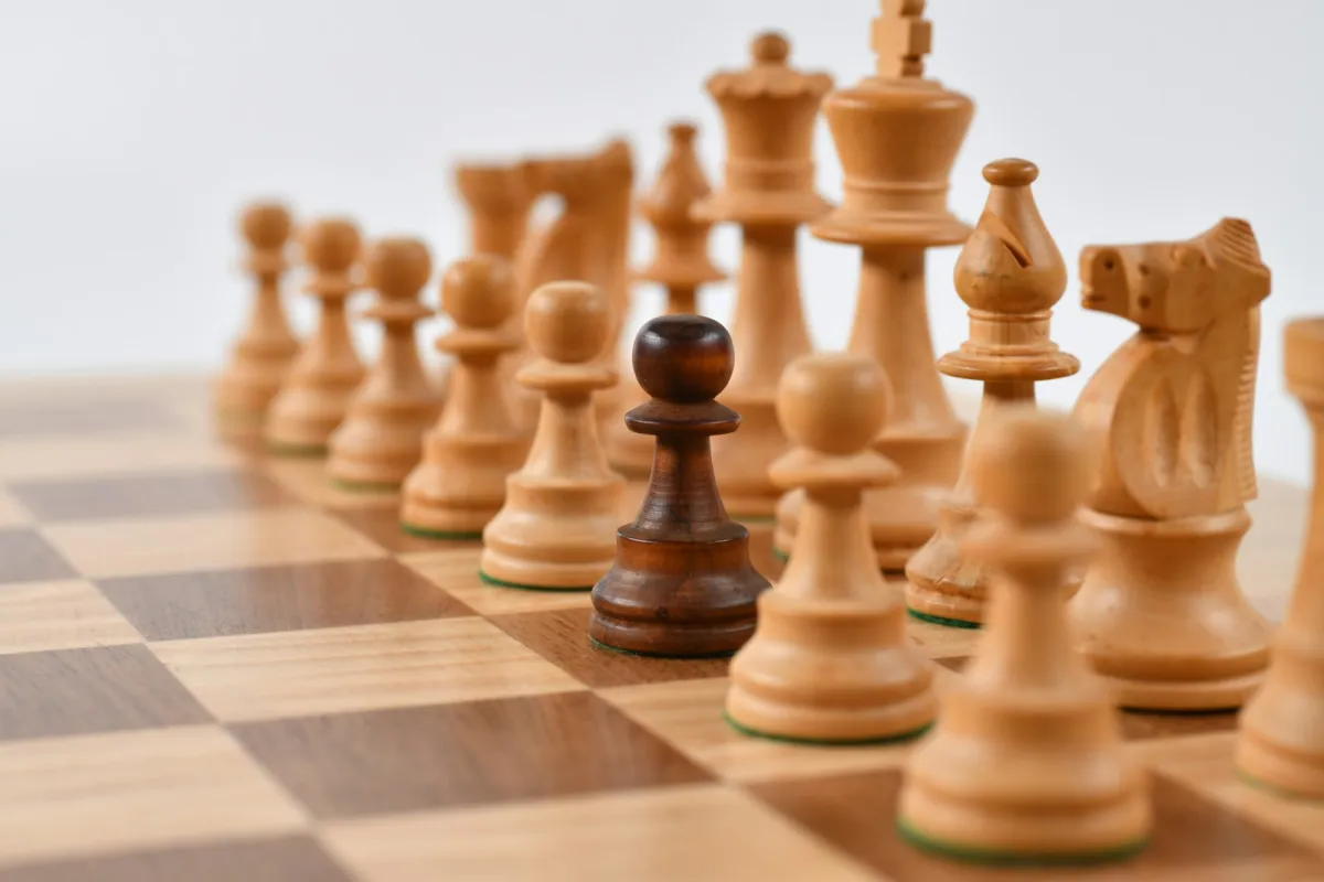 Wooden chess pieces lined up on a walnut and maple board Wooden chess pieces lined up on a walnut and maple board