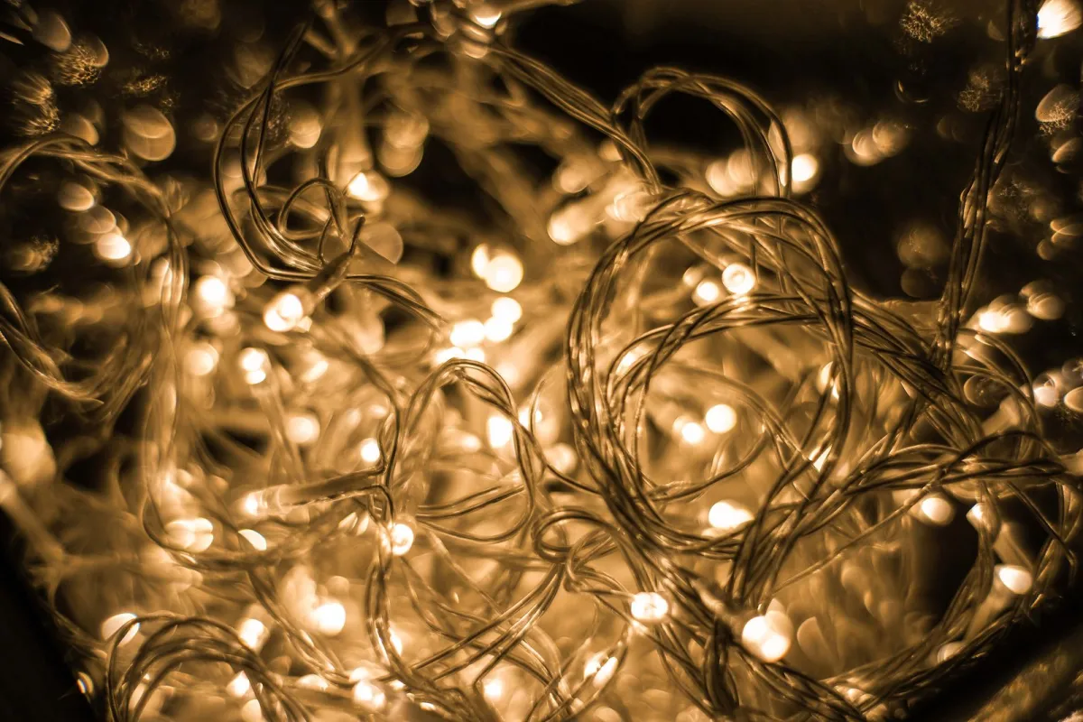A tangle of warm white LED string lights glowing in the dark A tangle of warm white LED string lights glowing in the dark