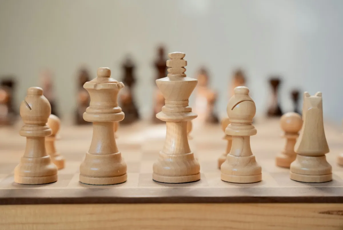 Close-up of light wooden chess pieces lined up on a board