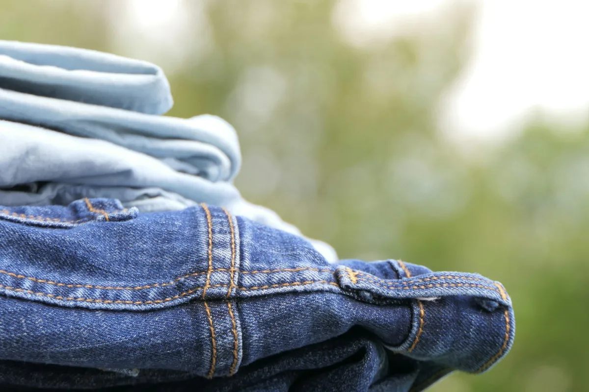 A stack of folded blue jeans in light and dark washes A stack of folded blue jeans in light and dark washes