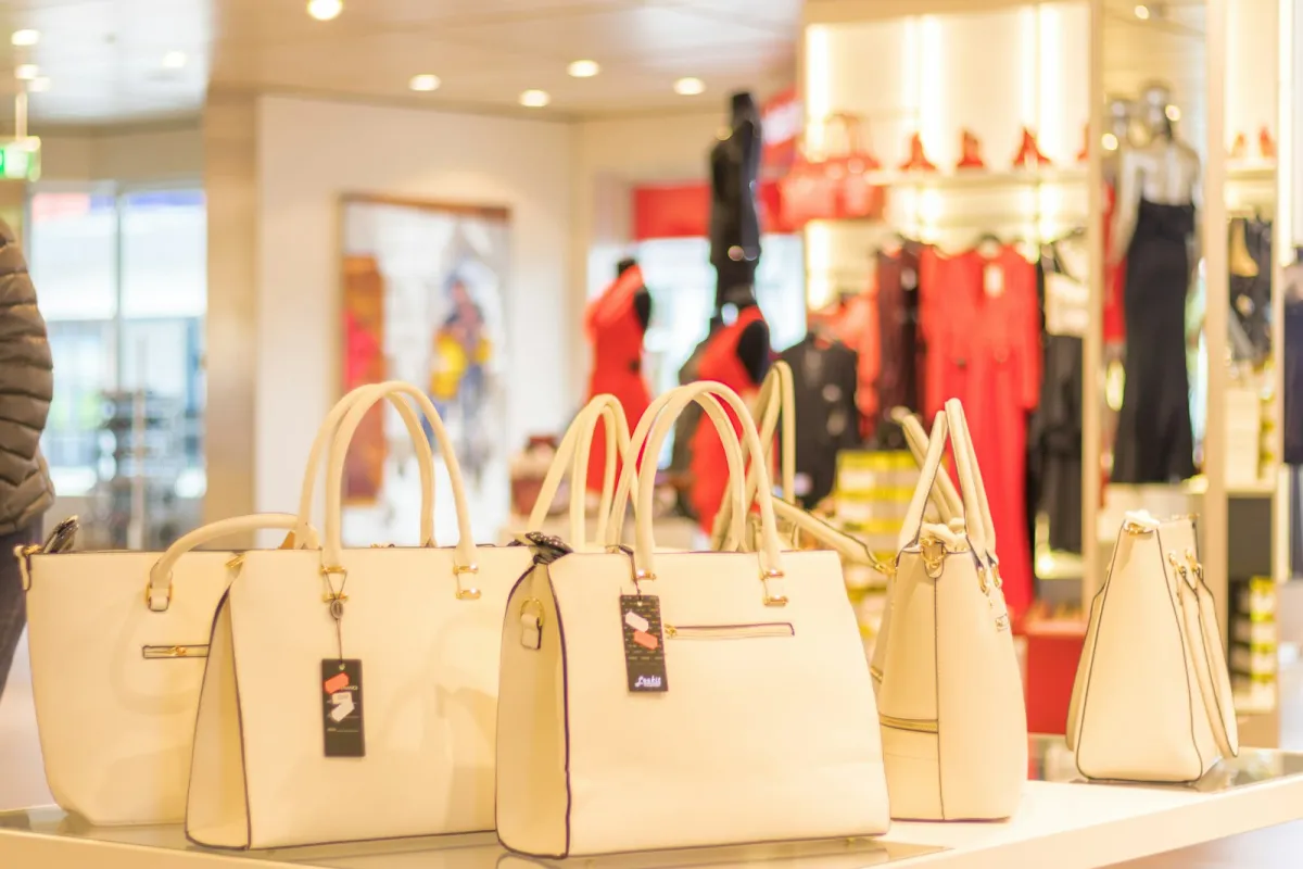 Cream leather handbags displayed on a table in a fashion boutique Cream leather handbags displayed on a table in a fashion boutique