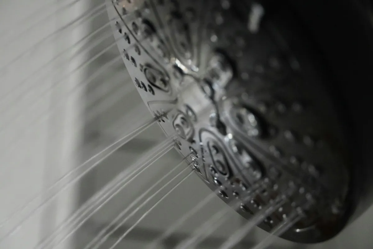 Close-up of a chrome shower head with water spraying out Close-up of a chrome shower head with water spraying out