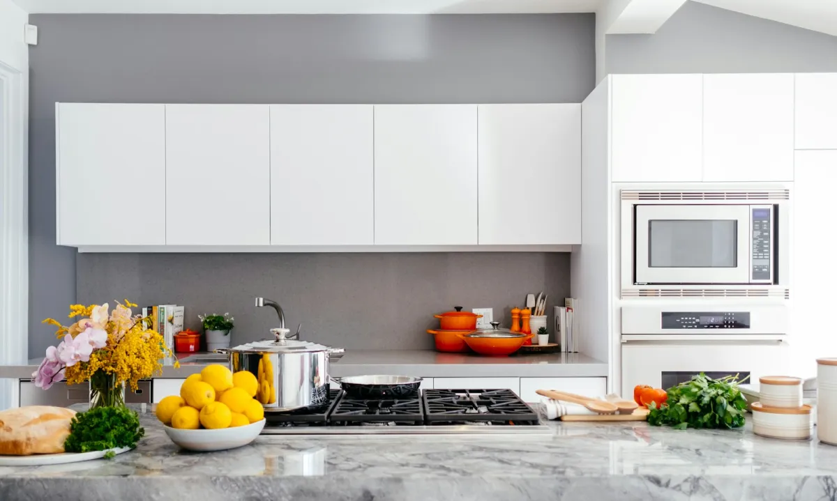 Bright modern kitchen with a built-in oven and microwave, gas hob and marble worktop Bright modern kitchen with a built-in oven and microwave, gas hob and marble worktop