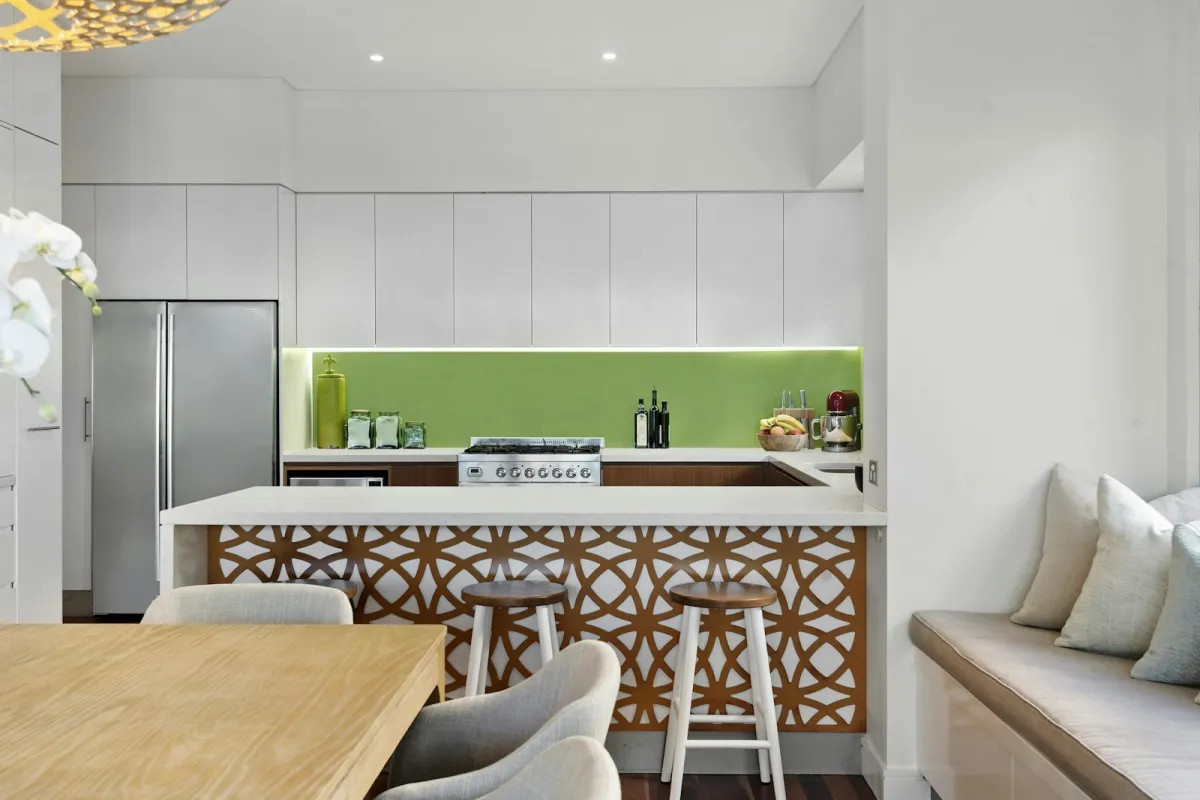 Modern white kitchen with a bright green splashback behind the range cooker Modern white kitchen with a bright green splashback behind the range cooker