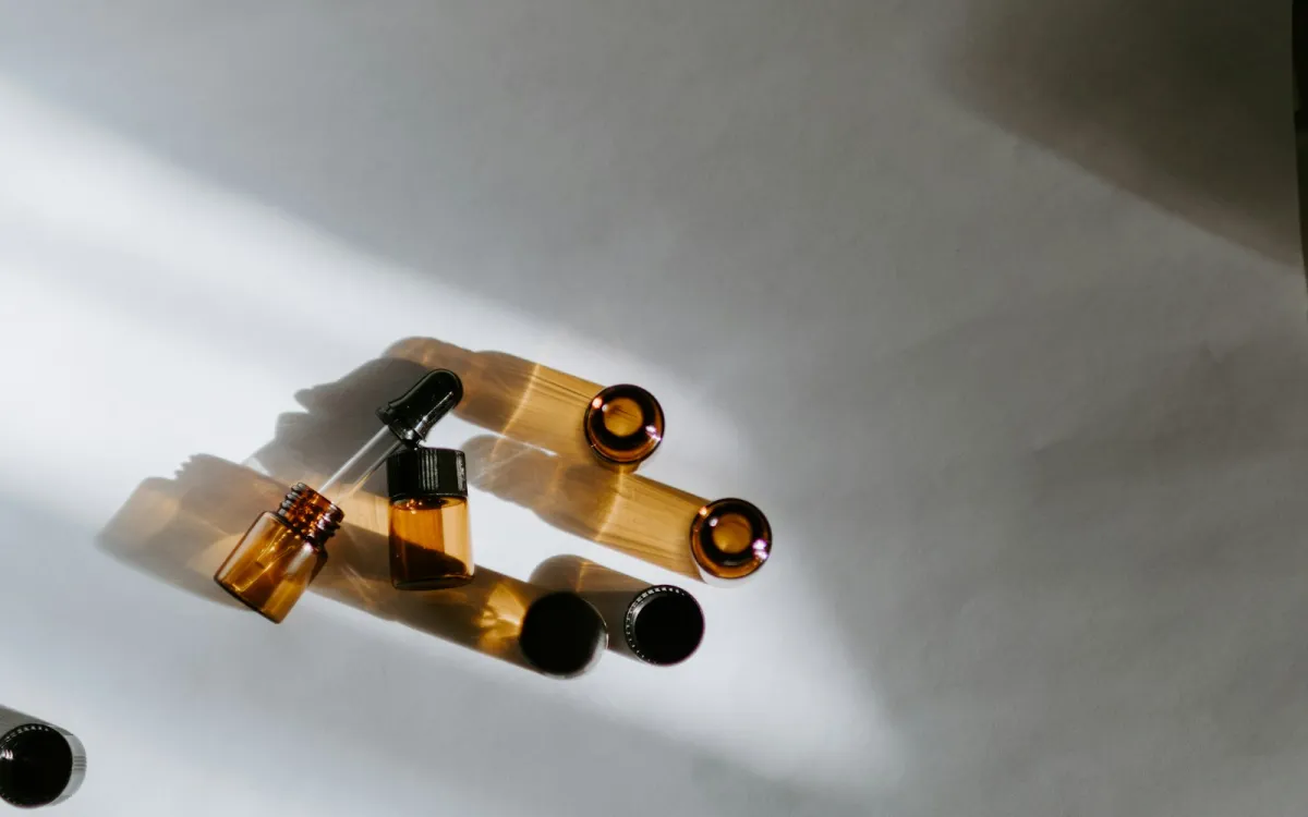 Small amber glass essential oil bottles and a dropper in sunlight Small amber glass essential oil bottles and a dropper in sunlight
