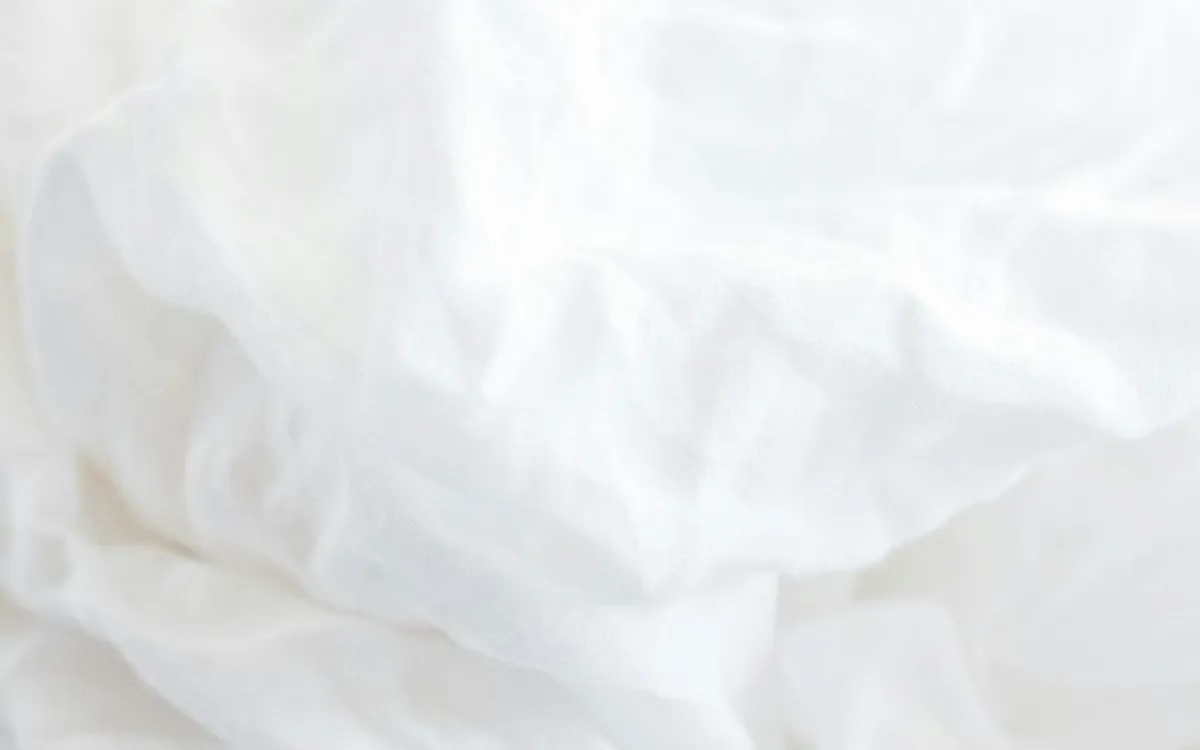 Soft white bed linen in natural light