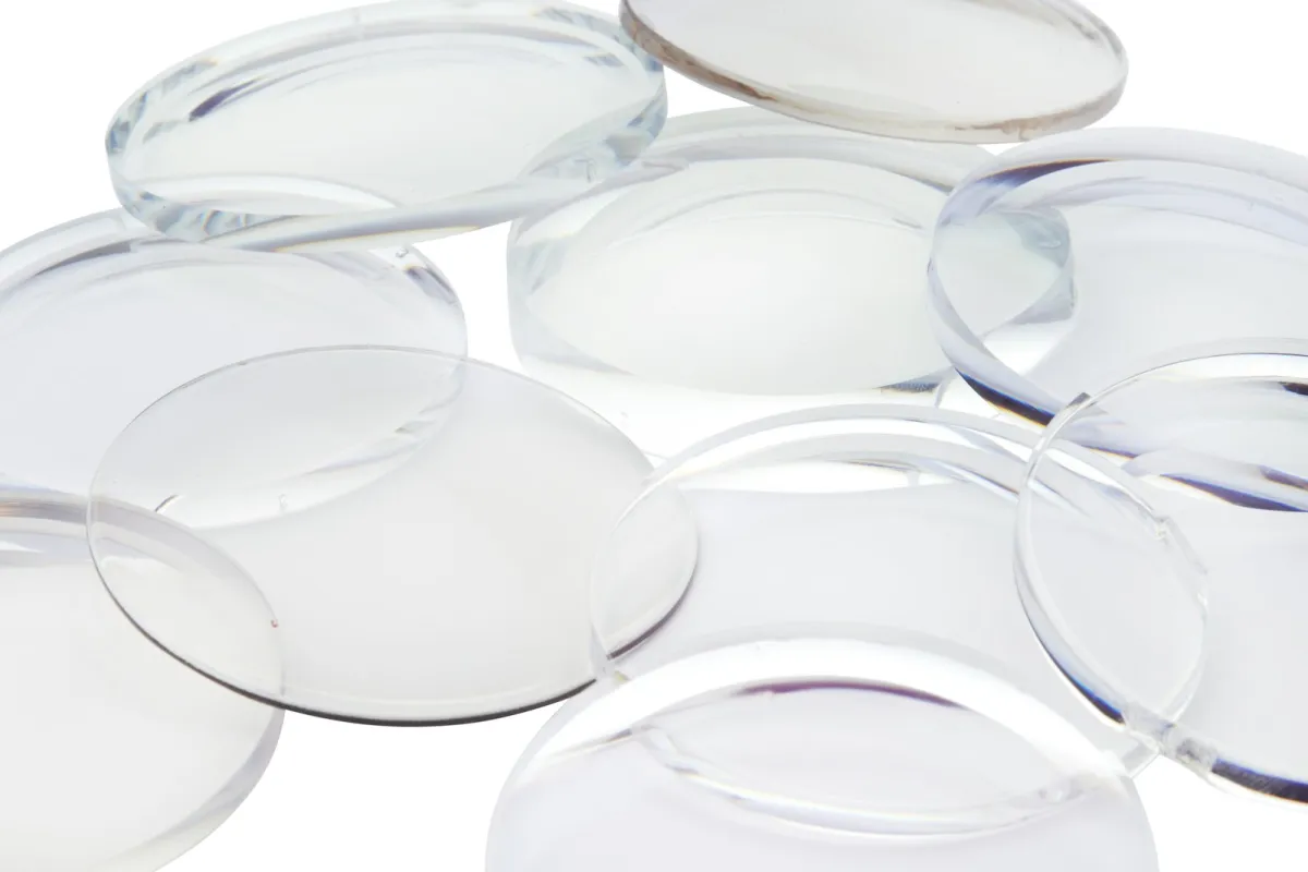 A scattering of clear optical lenses on a white surface A scattering of clear optical lenses on a white surface