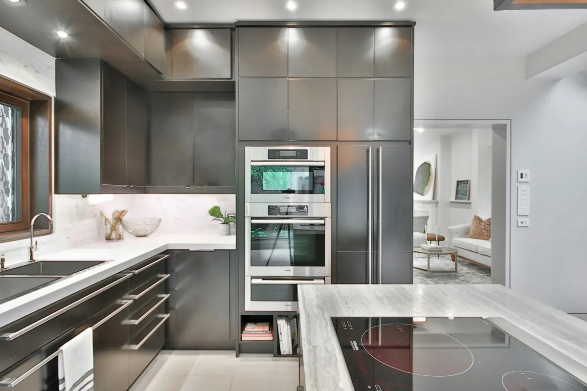 A modern grey kitchen with built-in stainless steel ovens and an induction hob A modern grey kitchen with built-in stainless steel ovens and an induction hob