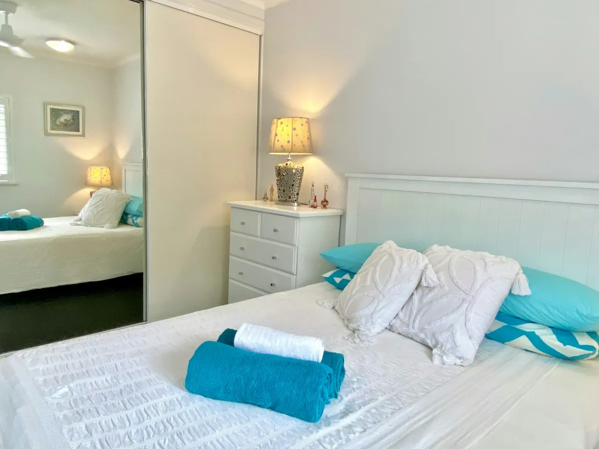 White wooden bed frame made up with white pillows White wooden bed frame made up with white pillows