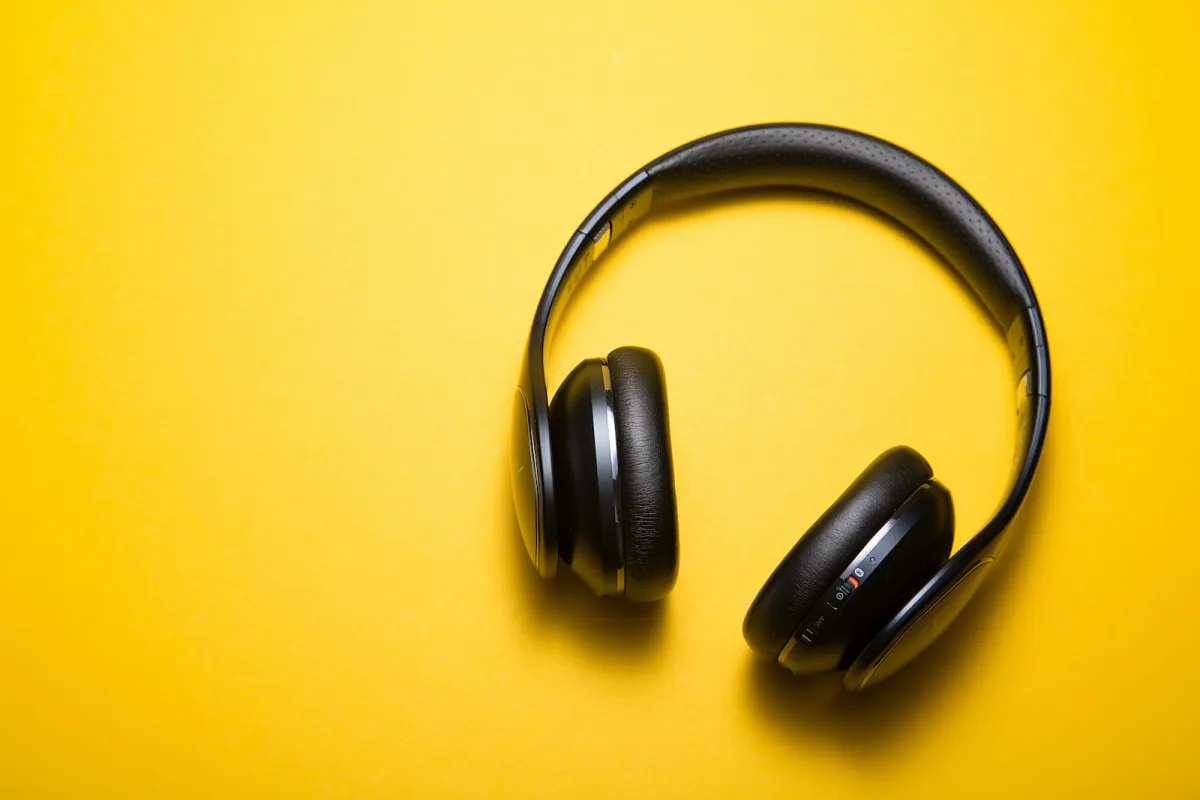 Black wireless headphones on a yellow background Black wireless headphones on a yellow background