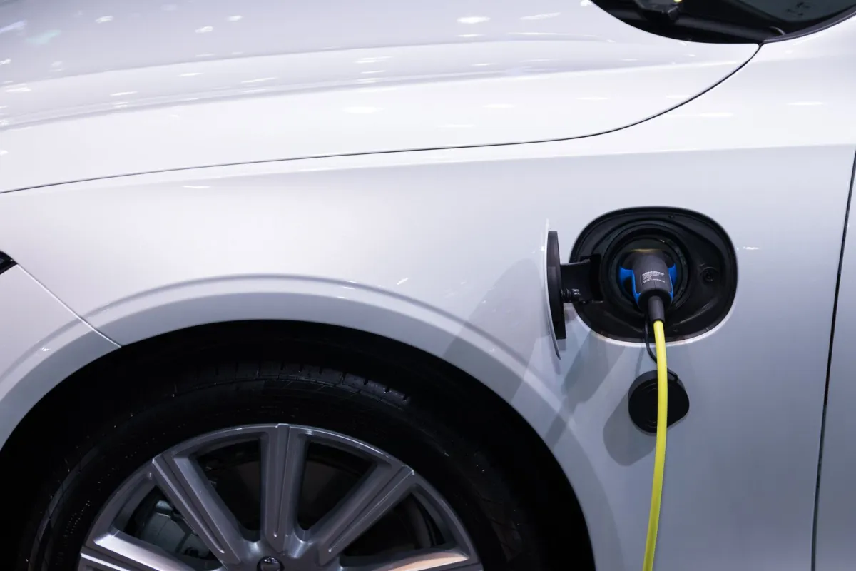 Silver electric car plugged in with a yellow charging cable