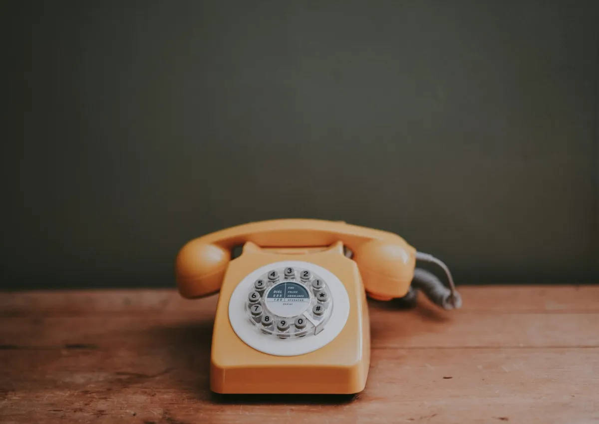 Old-fashioned rotary dial telephone on a wooden table Old-fashioned rotary dial telephone on a wooden table