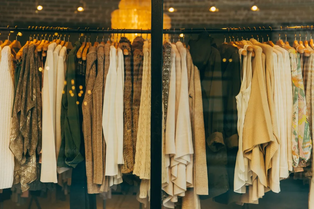 Rail of neutral-toned women's tops and knitwear in a boutique window Rail of neutral-toned women's tops and knitwear in a boutique window