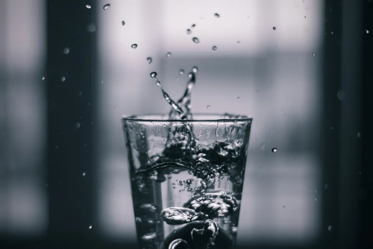 Water splashing into a clear drinking glass