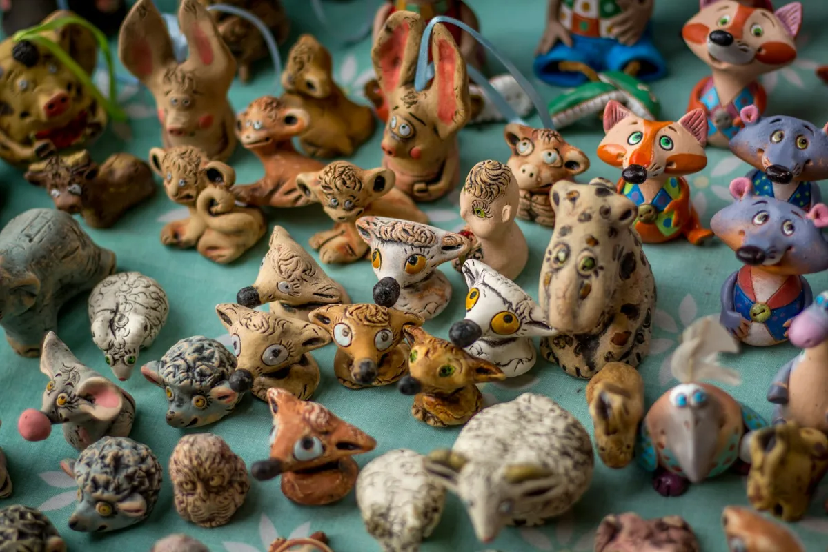 Rows of small hand-painted animal figurines on a tablecloth Rows of small hand-painted animal figurines on a tablecloth