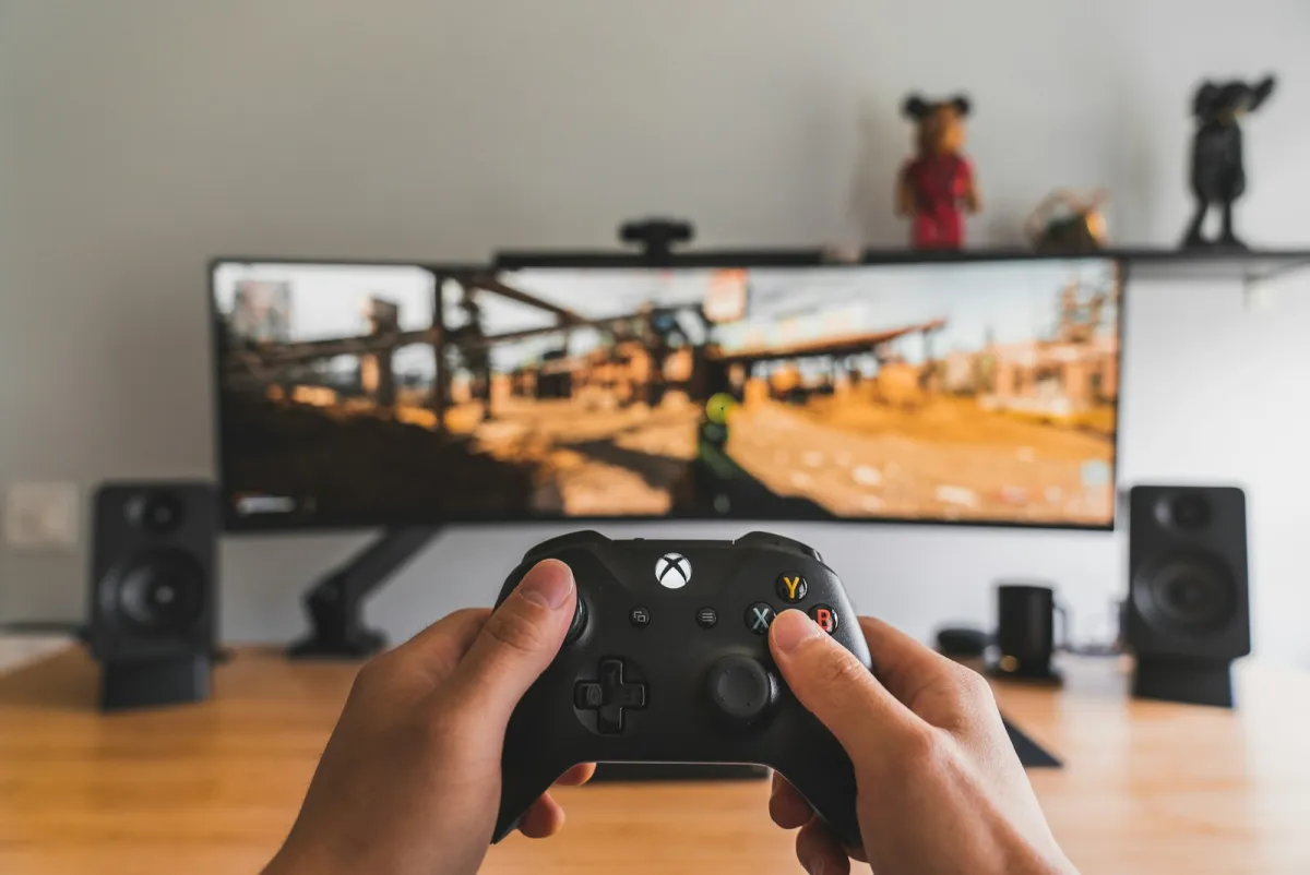 Hands holding a black game controller Hands holding a black game controller