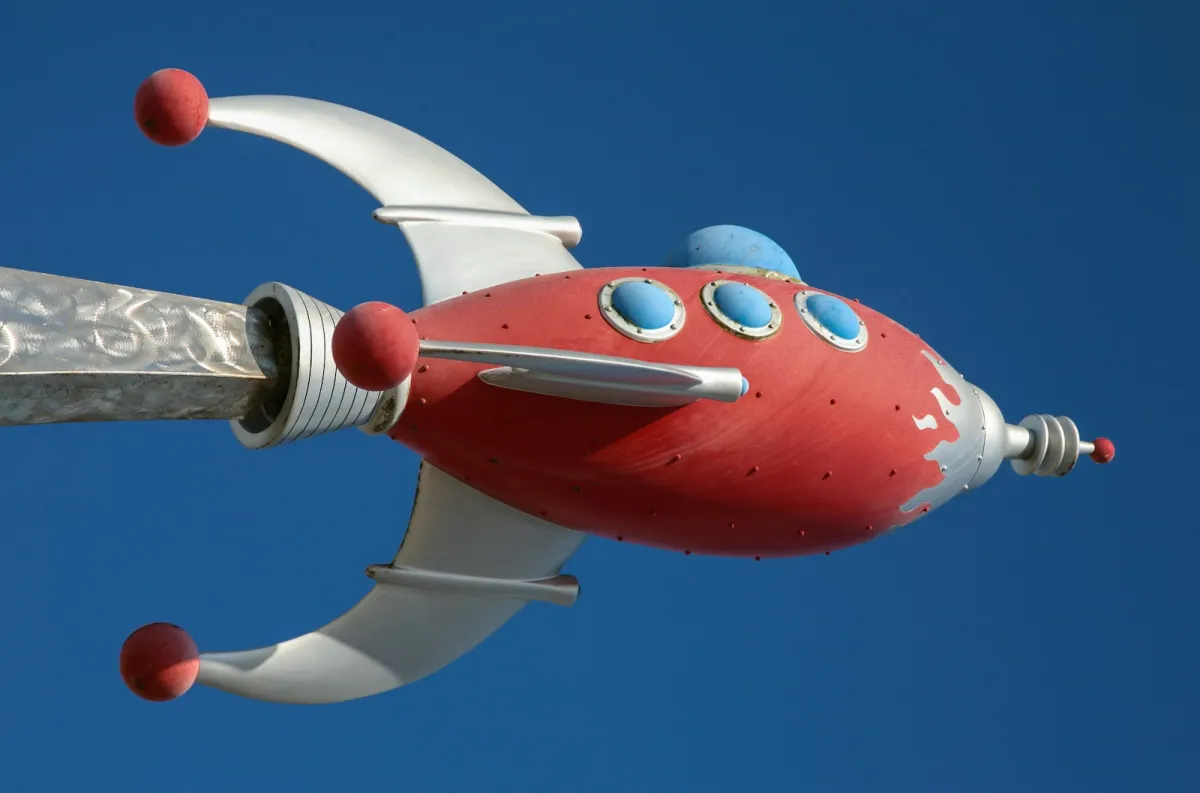 Retro red and silver rocket ship against a deep blue sky
