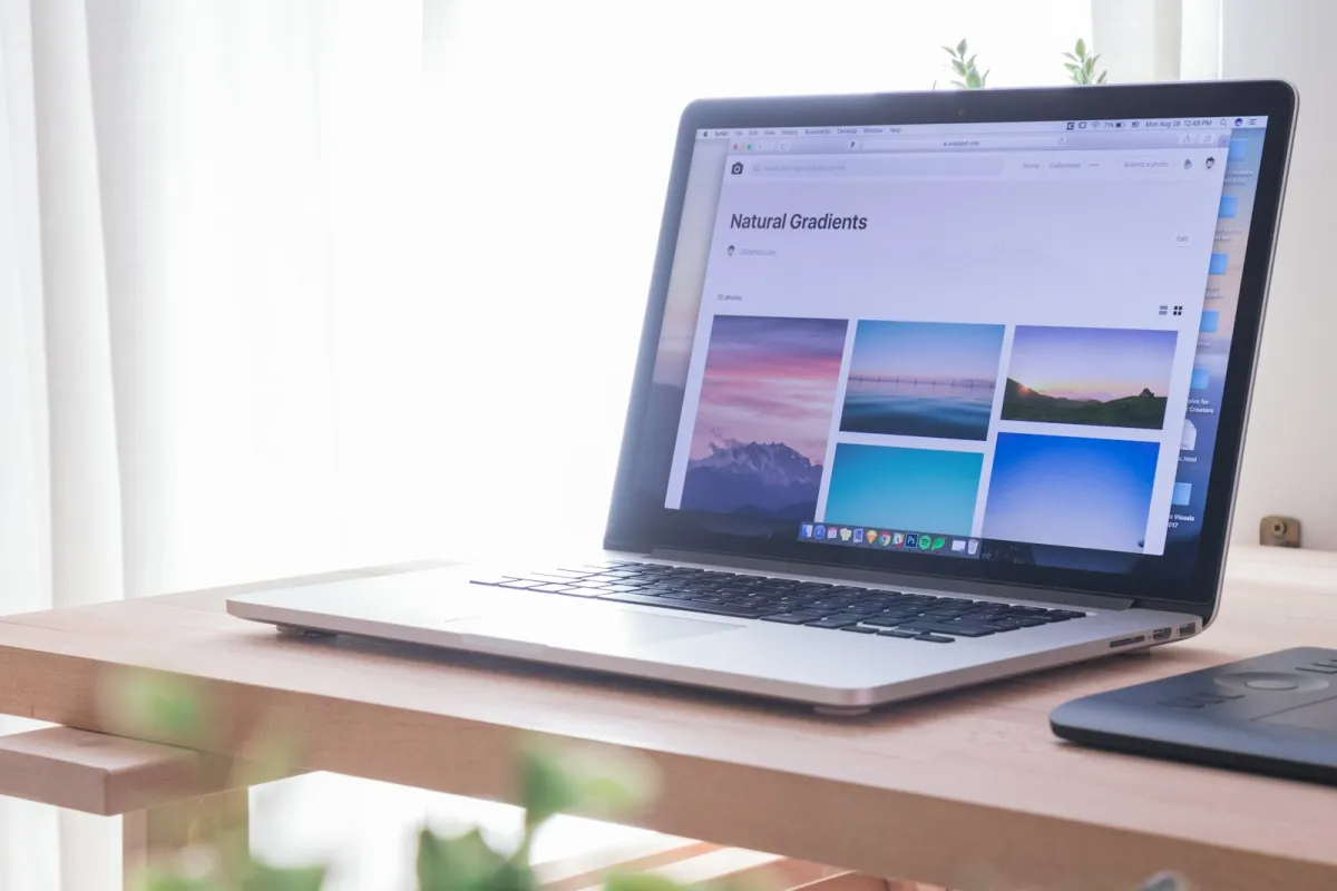 Open laptop on a light wooden desk by a bright window Open laptop on a light wooden desk by a bright window