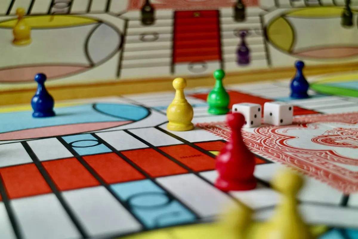 Colourful game pieces and two white dice on a board game