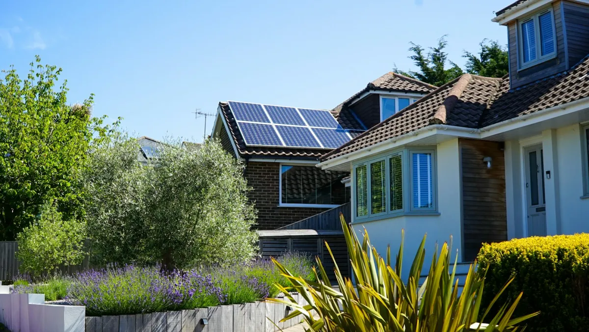 A house with solar panels on its roof and large first-floor windows