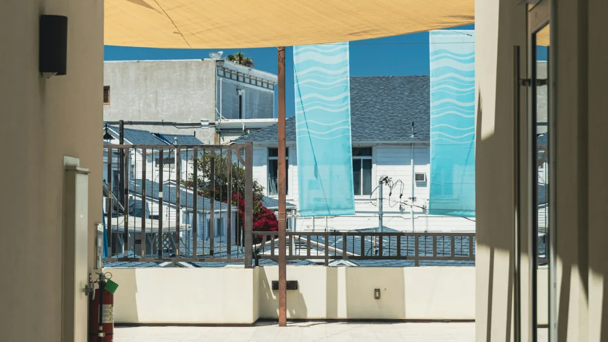 A sand-coloured shade sail stretched over a sunny roof terrace