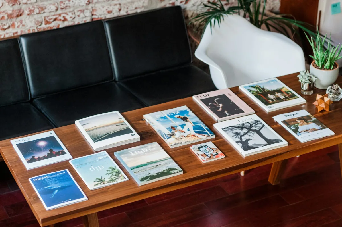 A selection of magazines laid out on a wooden coffee table
