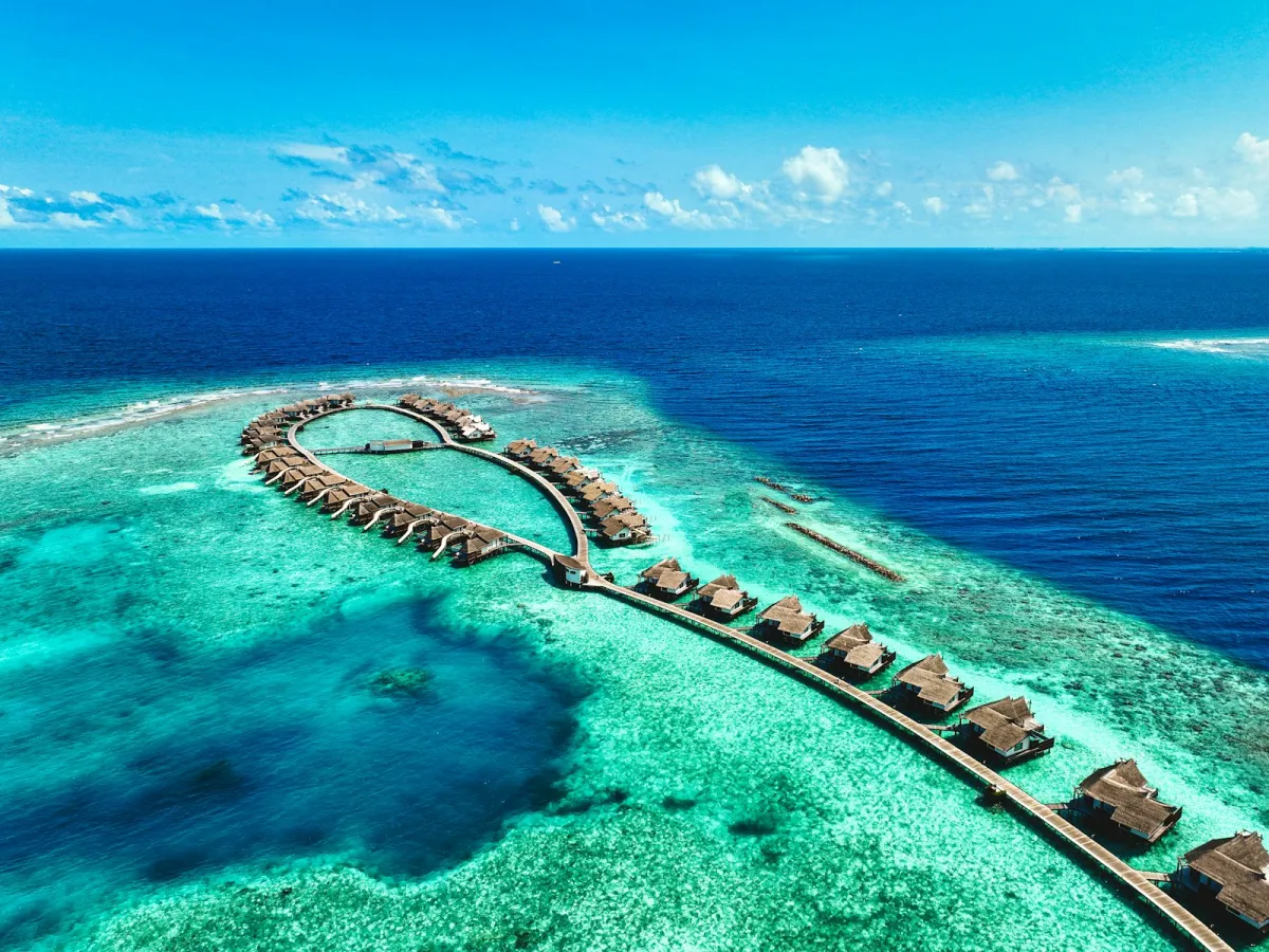 Aerial view of overwater villas on a turquoise reef in the Maldives Aerial view of overwater villas on a turquoise reef in the Maldives