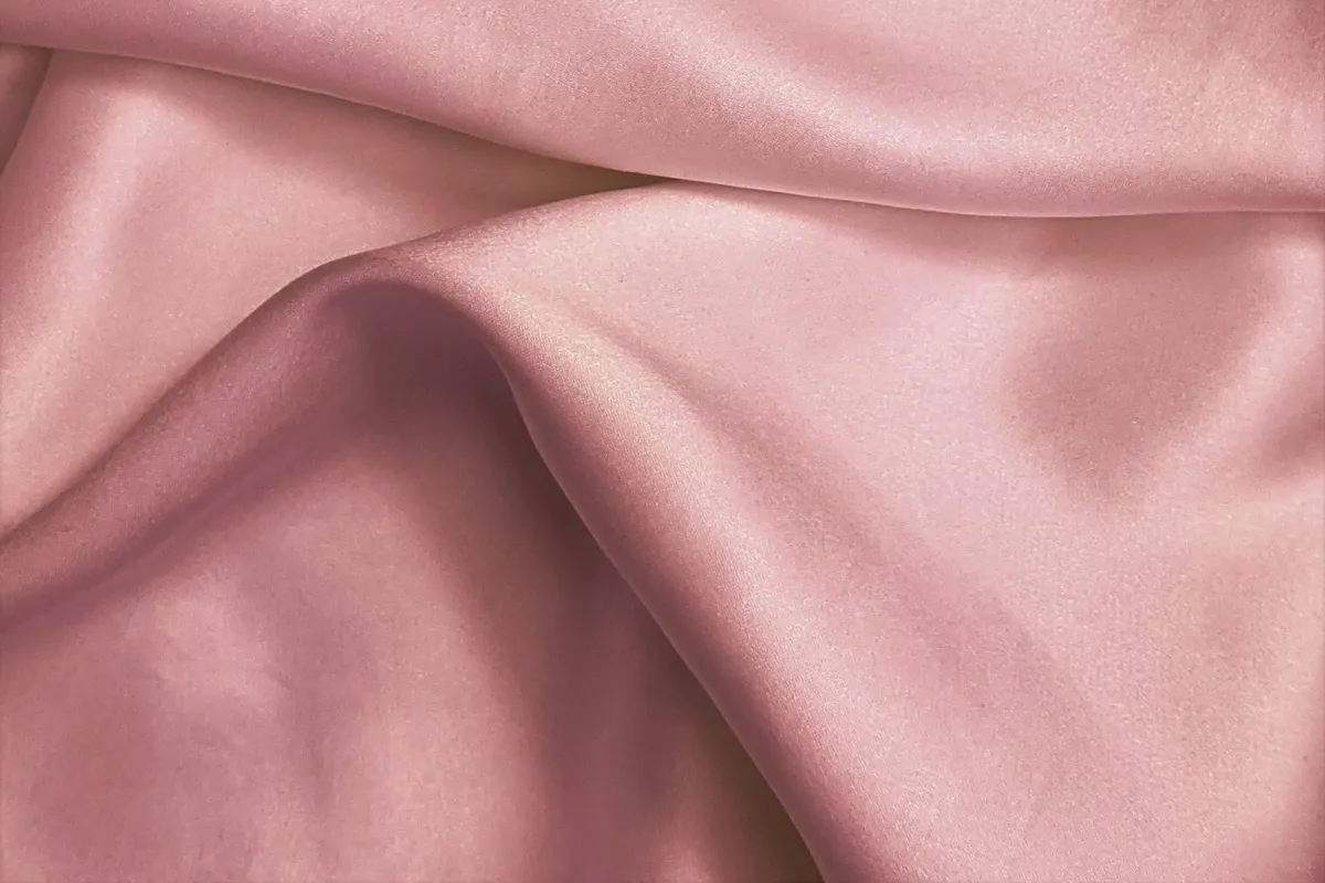 Soft folds of dusky pink silk fabric Soft folds of dusky pink silk fabric