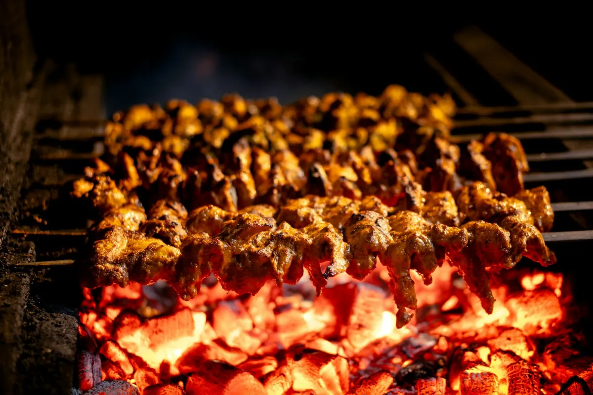 Meat skewers cooking over glowing charcoal Meat skewers cooking over glowing charcoal