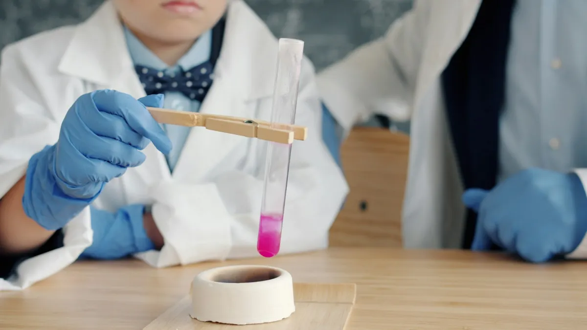 Children in lab coats and gloves holding a test tube of pink liquid