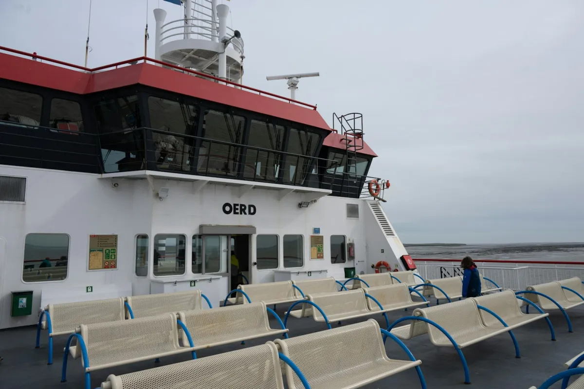 Rows of empty benches on the open top deck of a passenger ferry under a pale sky Rows of empty benches on the open top deck of a passenger ferry under a pale sky