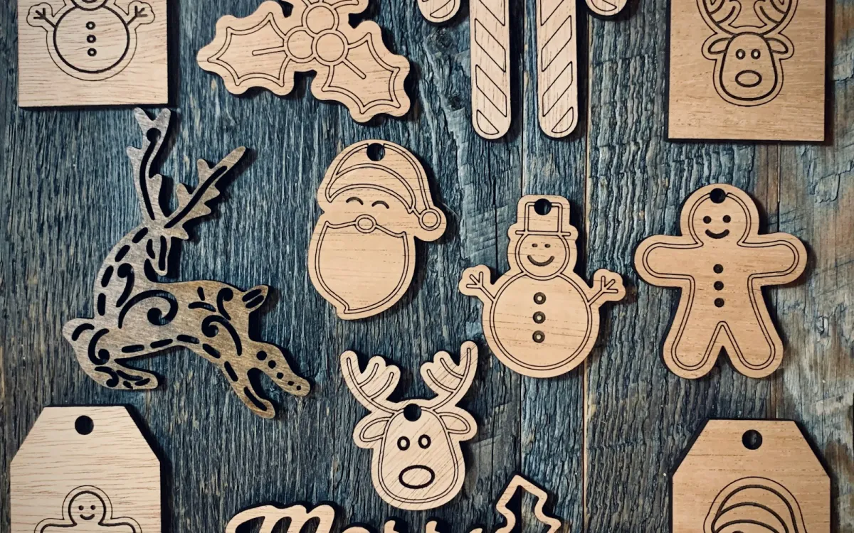 Laser-cut wooden Christmas tags and decorations on a dark wooden table Laser-cut wooden Christmas tags and decorations on a dark wooden table